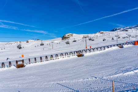 Alpes d'Huez, France - 31.12.2021: Magicagic carpet ski lift in a glass tunnel. Snowy winter day in...