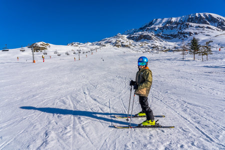 Alpe D'Huez, FRANCE - 01.01.2022: Boy skier posing on a mountain, holidays with children in the snow mountains concept. Famous ski resort in French Alps, France, Europe. Wintertimeのeditorial素材