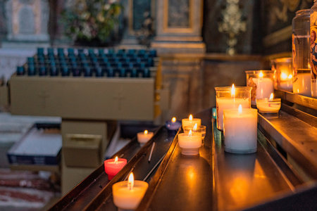 Candles in the Catholic Church. Beautiful glass windows with the evening light on the background. High quality photoの写真素材