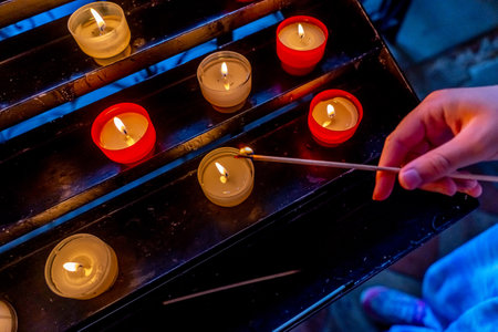 Candles in the Catholic Church. Beautiful glass windows with the evening light on the background. High quality photoの写真素材