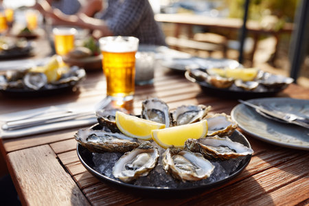 Plate of raw oysters with lemon, glass of dewed beer.の写真素材