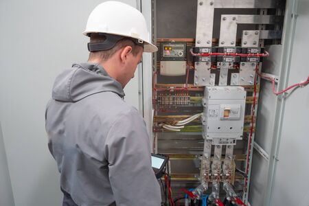 Electricians take measurements. Worker in uniform.