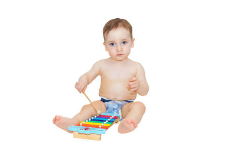 Cute little baby playing on musical instrument isolated on white backgroundの写真素材