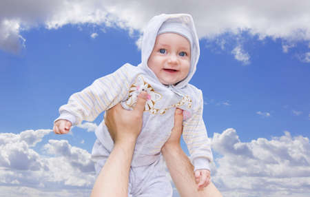 Hands man raised his cute child to the blue sky                 