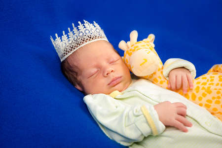 Beautiful newborn baby boy sleeping on a blue blanket with little toy. Three weeks Top viewの写真素材