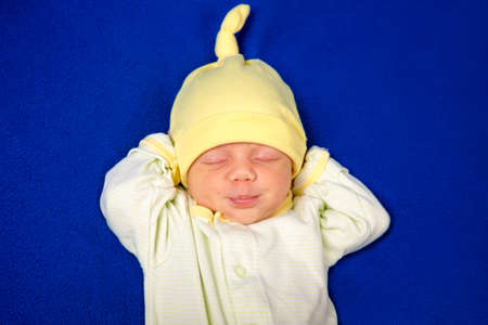 Cute newborn little boy sleeping on a blue blanket. Baby goods packaging template. Closeup portrait...