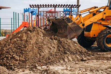Concept of the tractor, the tractor digs and buries a trench for laying water on a plot for the...