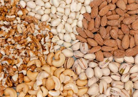 Assorted nuts background. Walnuts almonds, pistachios, cashews, peanuts. Healthy food and snack....