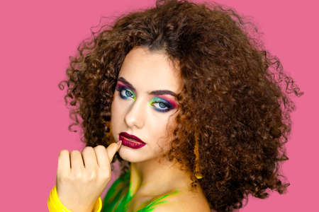 Charming model with professional makeup and painted body on a pink background. Summer style and image. The concept of perfect beautyの写真素材