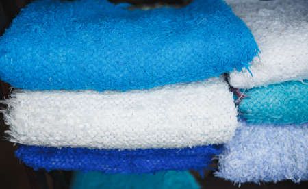 Soft cotton plaids made of natural yarn of different colors are folded neatly in a pile. Eco items...