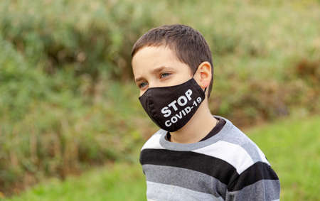 Boy in medical protective face mask. Lifting virus lockdown orders. Social distancing. Quarantine, illness, infection. Virus protection, coronavirus pandemic, covid 19 disease, prevention epidemicの写真素材