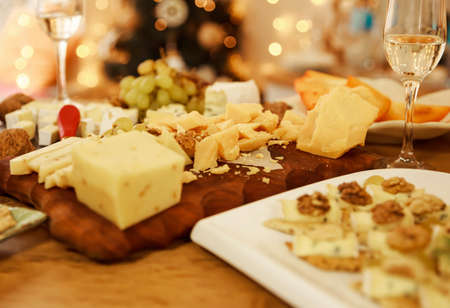 Food for wine and romantic, cheese delicatessen. Menu design horizontal. Different kinds of cheeses, wine and snacks. Still life on rustic wooden table. French food tasting party or feast scenery.の写真素材