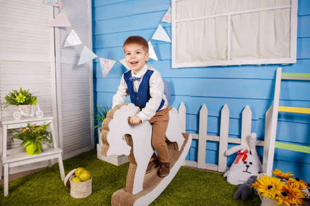 Birthday party for cute child. Fun, joy, celebration and holiday. Surprised kid looking at camera on blue background. Little baby boy celebrating his birthday. Trendy children clothes, party conceptの写真素材