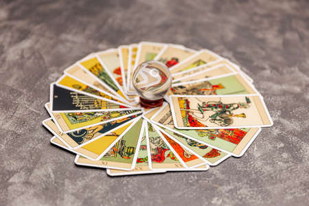 Set of tarot cards on the table. Tarot cards and magic crystal ball. Crystal ball to predict the fate. Guessing for the future. Mixed tarot cards on the table with a magic orb. Future readingの写真素材