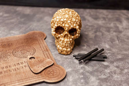 Witches den with a talking spirit board, surrounded a skull, engulfed in mysterious and murky smoke....
