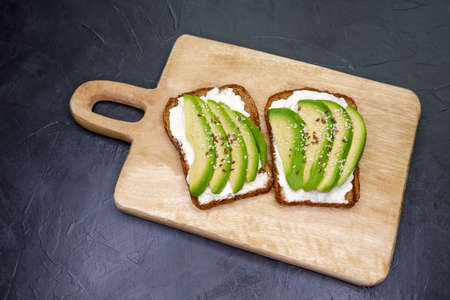 Cereal bread toast is on the table. Sandwiches with soft cheese. Bruschetta with cottage cheese,...