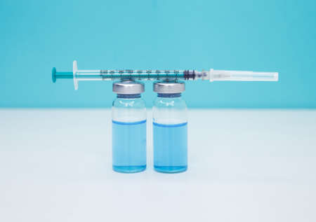 Doctor preparing the vaccine. A vaccine against disease. Covid-19 vaccination background. Coronavirus vaccine bottles and syringe injection. Medicine vials and syringe. Healthcare and medical concept.の写真素材