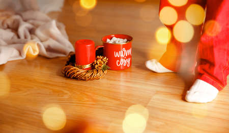 Boy in pyjamas drinking hot chocolate. Little boy sipping a cup of hot chocolate with marshmallows. Christmas, New Year decoration. Drinking hot chocolate. Preparing for a family holiday, happy eveの写真素材