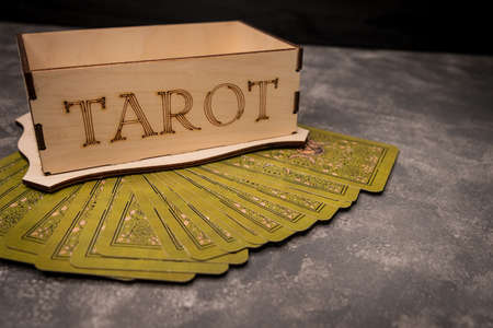 Items for divination in dark room. Tarot cards spread on table with crystal ball. Fortune telling on tarot cards at night by candlelight. Magic crystal, occultism. Esoteric background. Predictionsの写真素材