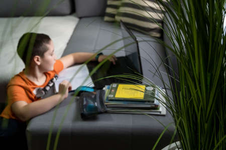 Lock down. Home schooling. Social distance. E-learning online education. Kid self isolation using tablet for his homework,Child doing using digital tablet searching information on internet.の写真素材