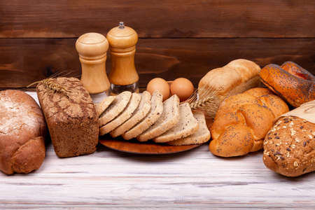 Concept of homemade bread, natural farm products, domestic production. Healthy and tasty organic food. Assortment of baked bread on wooden background. Empty space for text. Baking concept.の写真素材