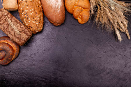 Assortment of baked bread. Loaves of rye. Wholegrain bread. The range of different types of bakery products from rye and wheat flour. Fresh fragrant bread on the table. Food concept.の写真素材