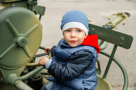 Little boys playing with historical world war tank. portrait of young boy. boy playing military tank. Low angle view of boy against clear sky. children's imagination and development. kid playing warsの写真素材