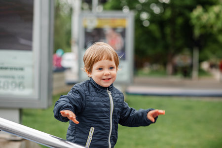A young boy cheering. Child smiling and looking at camera. Portrait of adorable brunette boy. Portrait of a serious young boy. Little shocked kid. Child child outdoors on a warm sunny summer day.の写真素材