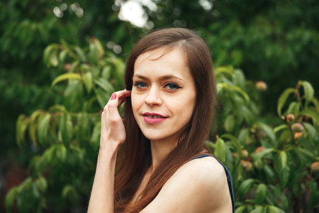 Portrait laughing sensual woman. A girl standing outside in nature. Portrait of cheerful woman standing at park. Young beautiful woman exercise in the forest. Portrait of pretty girlの写真素材