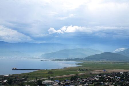 Clouds and mountains of lakeside in the village. Beautiful abstract blue illustration on light backdrop. Summer Sky blue background. Nature landscape.の写真素材