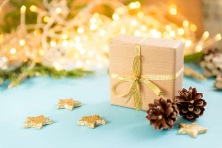 Christmas gift box on a background of glowing garlands. sky blue background with Christmas toys. New...