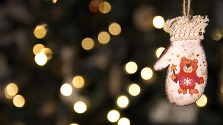 Christmas toy close-up on the background of a bokeh from a garland. Christmas lights. Wooden toy...