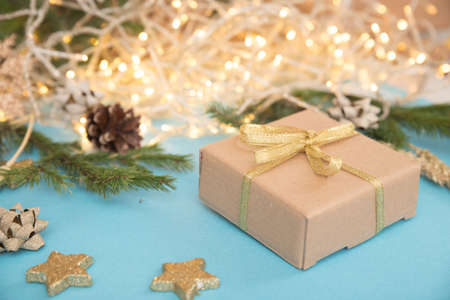 Christmas gift box on a background of glowing garlands. sky blue background with Christmas toys. New...