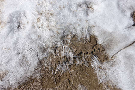 Ice floes. Melting crushed ice on the wet ground. Spring melting of snow and ice. Mud and slush. Close-up.の写真素材