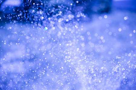 Blurred drops from a water fountain, defocus light, blur bokeh. background as a design element....