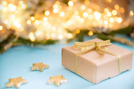 Christmas gift box on a background of glowing garlands. sky blue background with Christmas toys. New...