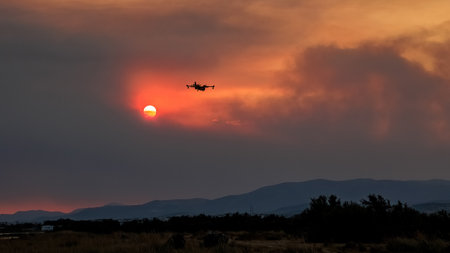 Devastating wildfire in Alexandroupolis Evros Greece, Aerial firefighting waterbombing planes silhouette, smoke covered the sky, sunset colors.の写真素材