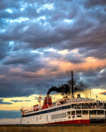 A boat in the seaport of Alexandroupolis Evros region Greece, black smoke in a cloudy sky.の写真素材