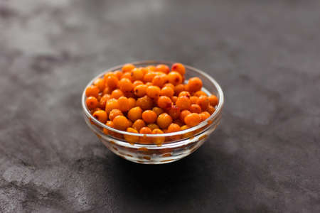 Close up frozen sea buckthorn berries on a dark background Healthy food vitamins snack dessert