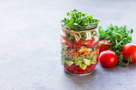 Vegetables salad in open jar Tomato, avocado, pepper, cucumber, micro greens Healthy food, diet, clean food and vegetarian conceptの写真素材