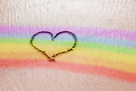 A heart painted on the sand with an LGBT symbolの写真素材