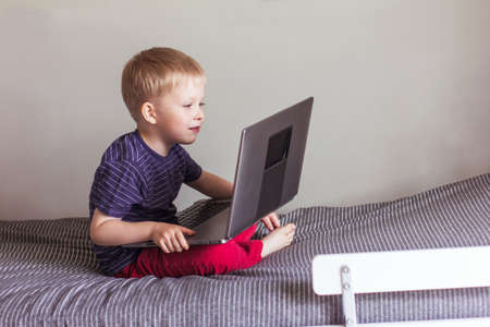 a small blond boy with laptop