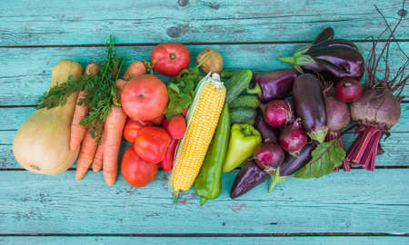 Assortment of fresh organic farm vegetables on a painted blue wooden background. Country-style market concept, local garden products, clean food dietの写真素材