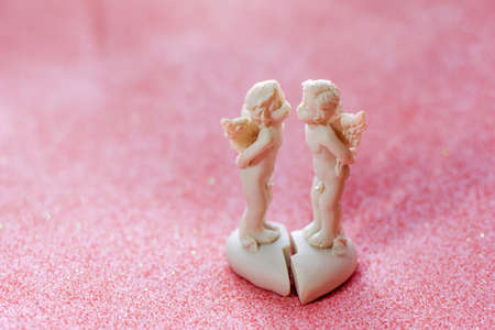 Two kissing angels on a light pink background with bokeh, the concept of Valentine's day, love, tenderness and happinessの写真素材