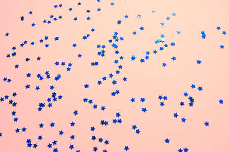 Blue sparkles and stars on pink pastel trendy background.