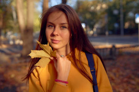 Beautiful caucasian young woman walking and having fun outdoors in autumn time