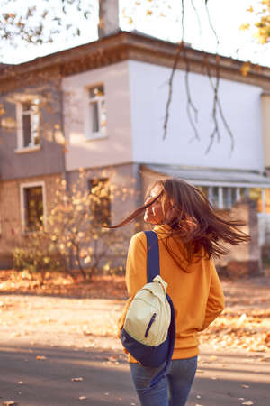 Beautiful caucasian young woman posing with red leaves in autumn time. Bright yellow colorsの写真素材