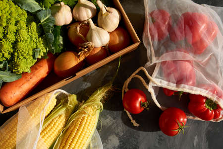 Fresh fruits and vegetables in reusable shopping bags.の写真素材