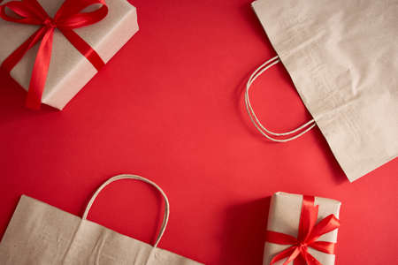 Presents with red ribbon on the bright background. Festive backdrop for holidaysの写真素材