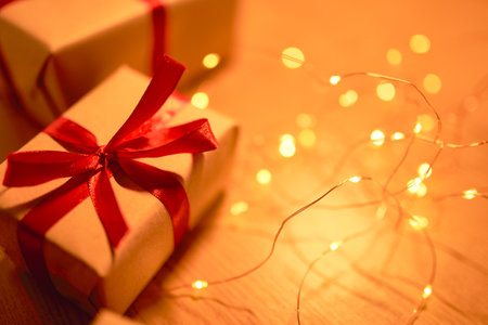 Christmas gift box with festive ribbons and lightsの写真素材